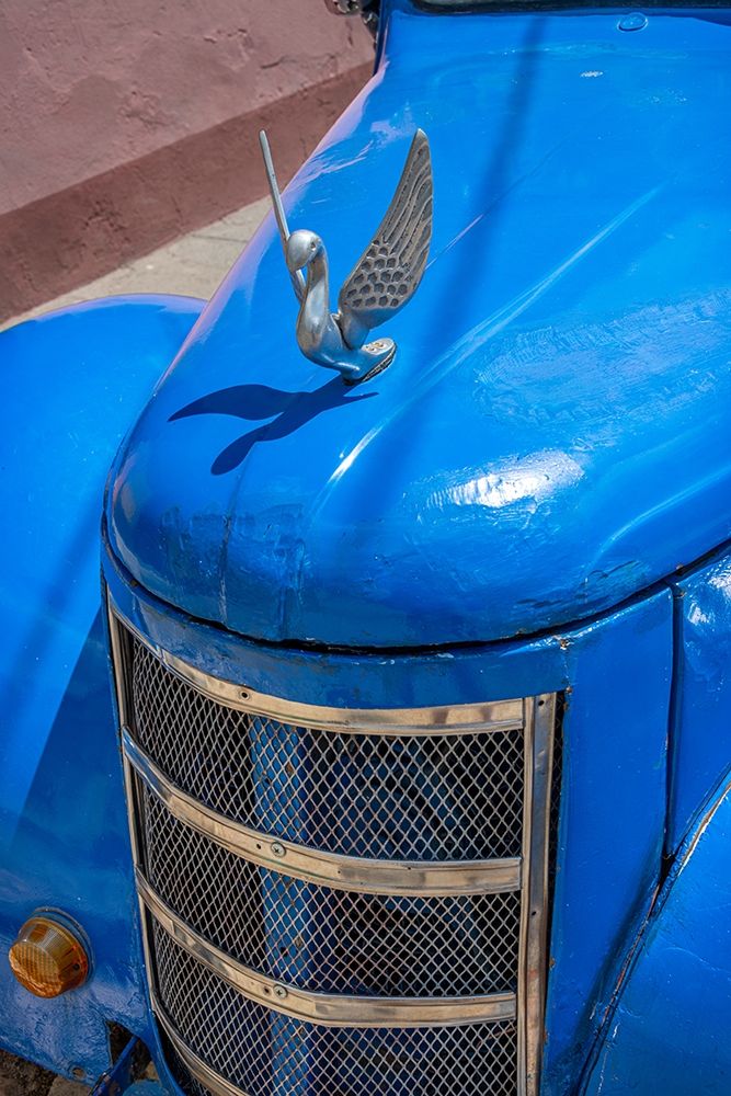 Detail of classic blue American car with chrome swan hood ornament in Trinidad-Cuba art print by Janis Miglavs for $57.95 CAD